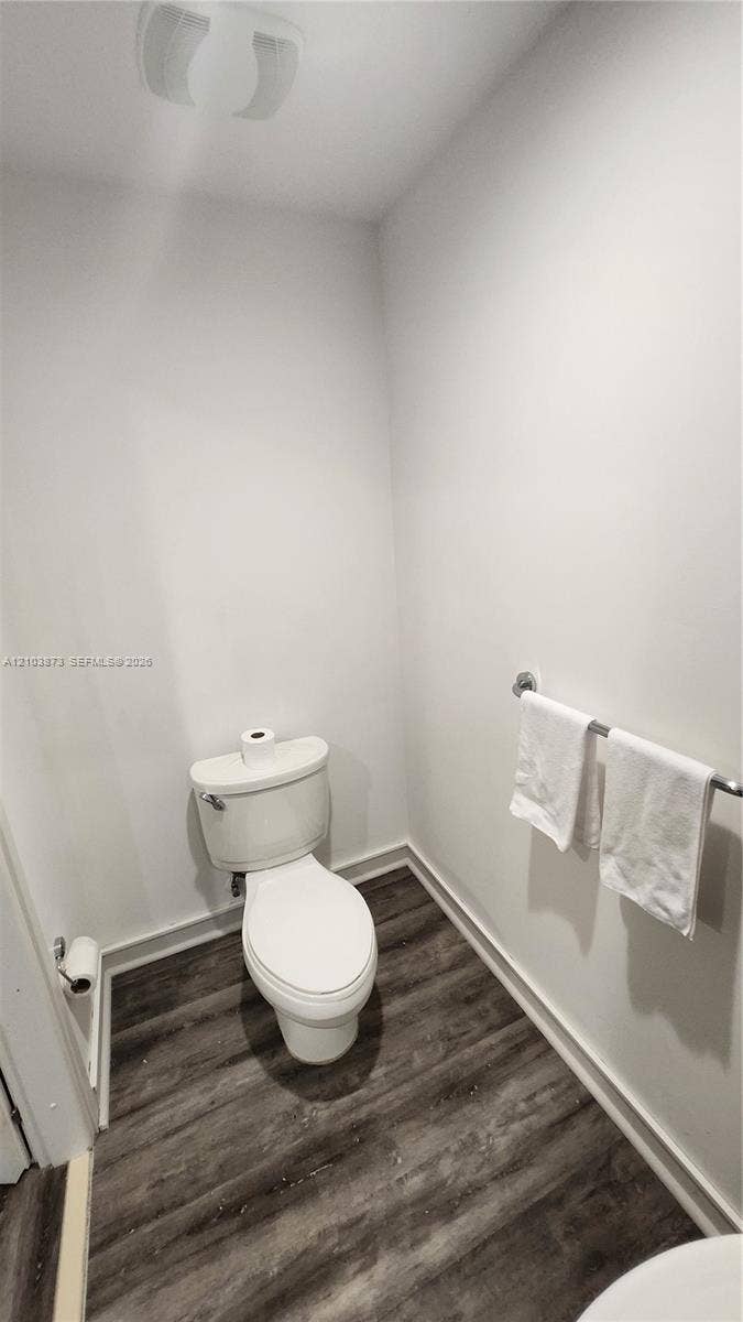 300 S Biscayne Boulevard, #L-808, Miami, FL 33131 Powder room featuring wood-finish flooring, a white porcelain toilet, and a wall-mounted metal towel rack