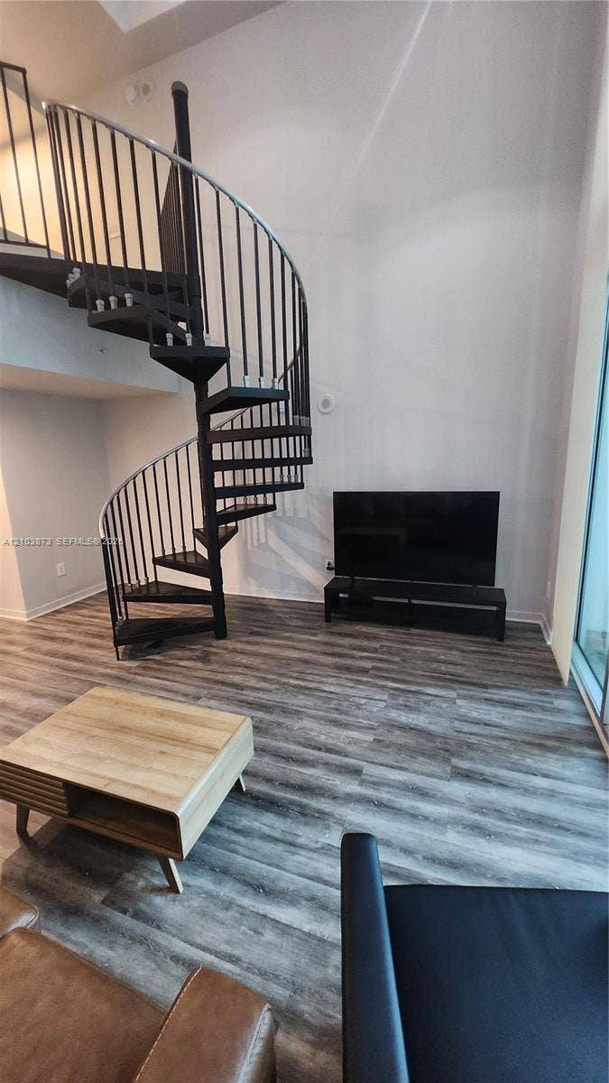 300 S Biscayne Boulevard, #L-808, Miami, FL 33131 Black metal spiral staircase with high-ceiling clearance and wood-finish flooring