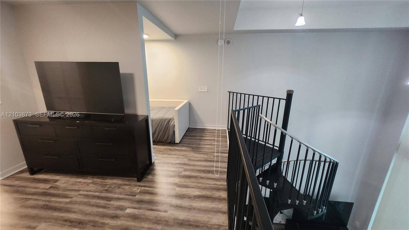 300 S Biscayne Boulevard, #L-808, Miami, FL 33131 Spiral staircase with matte black metal railings and wood-finish flooring throughout