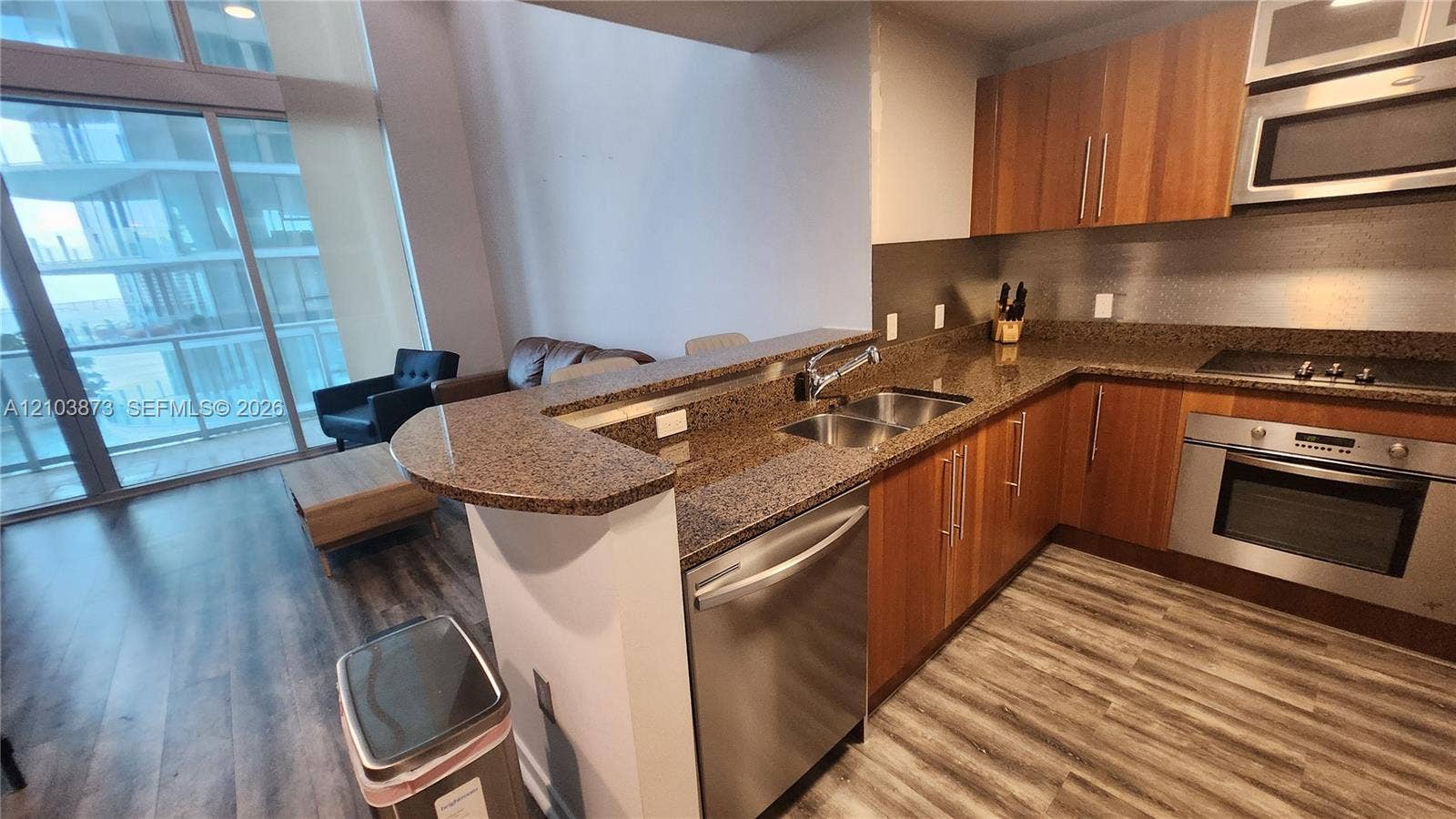 300 S Biscayne Boulevard, #L-808, Miami, FL 33131 Kitchen featuring wood-finish cabinetry, stone-surface countertops, stainless steel appliances, a dual-basin undermount sink, and wood-finish flooring