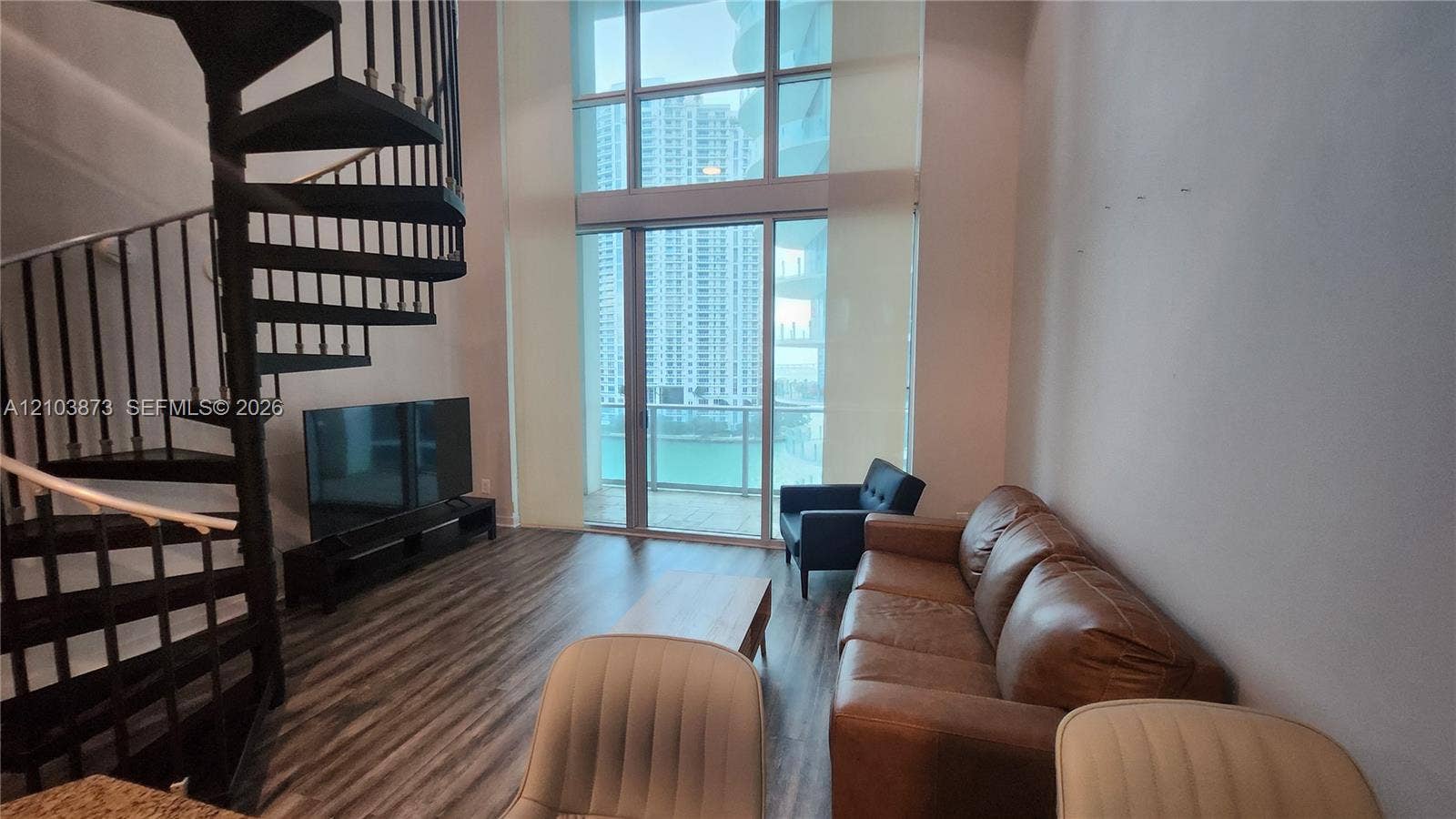 300 S Biscayne Boulevard, #L-808, Miami, FL 33131 Double-height floor-to-ceiling windows, metal spiral staircase, and wood-finish flooring