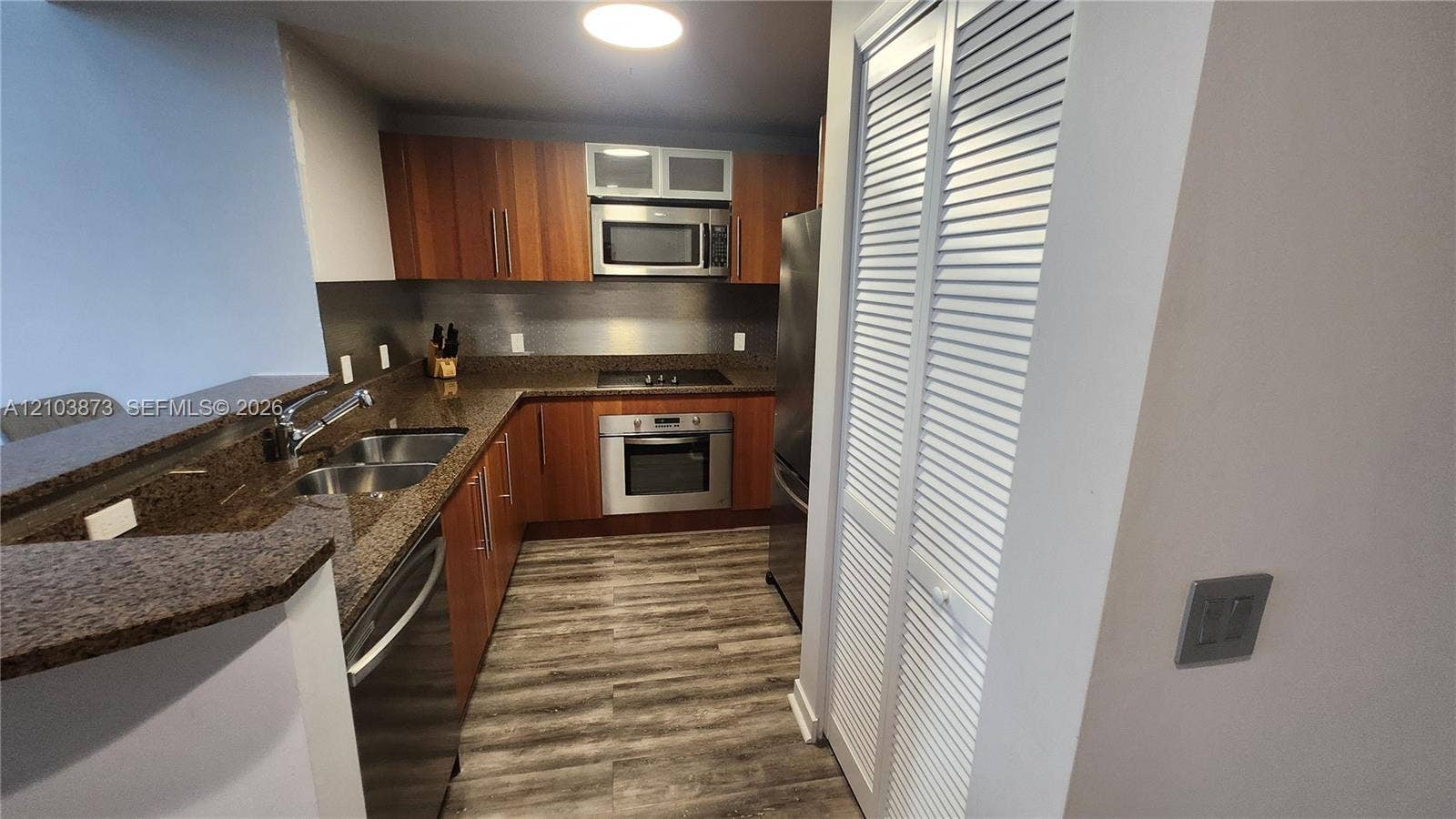 300 S Biscayne Boulevard, #L-808, Miami, FL 33131 Kitchen featuring wood-finish cabinetry, stone-surface countertops, stainless steel appliances, and wood-finish flooring