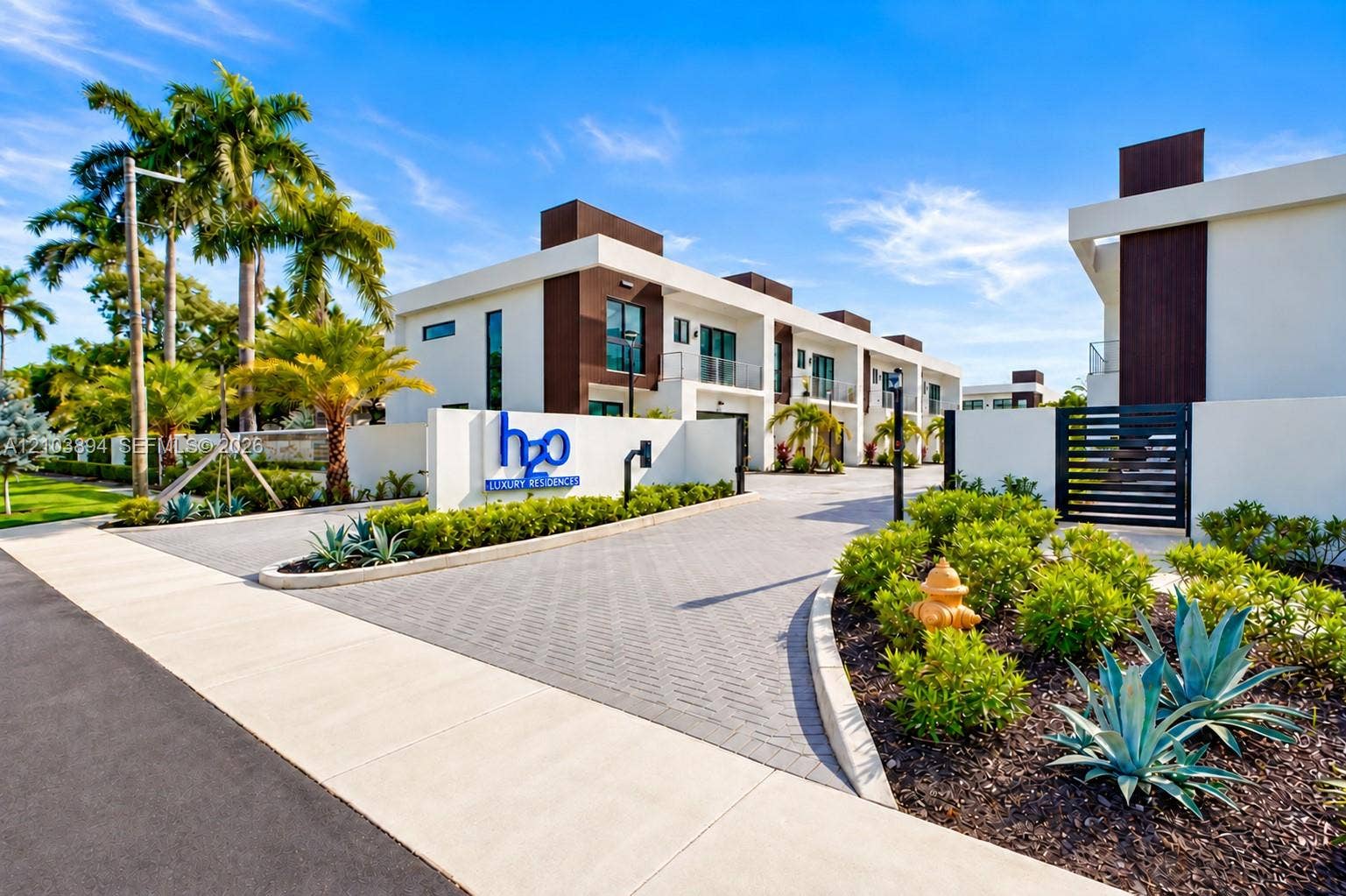 4648 SW 32 Nd Avenue, #B-3, Dania Beach, FL 33312 Modern multi-story residential complex featuring contemporary stucco and wood-panel exterior architecture, paver-stone driveway, gated entry, and manicured landscaping