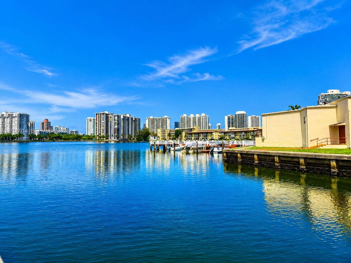Waterfront property featuring a concrete seawall and a private dock with multiple boat slips
