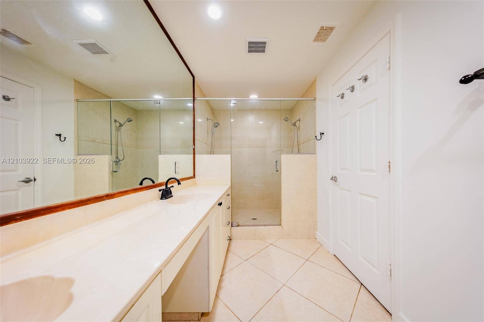 Expansive vanity with integrated countertop, full-width mirror, and matte black fixture
