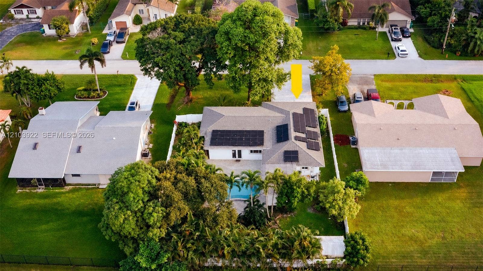 Single-story residence with a gray roof, solar panels, and an integrated swimming pool