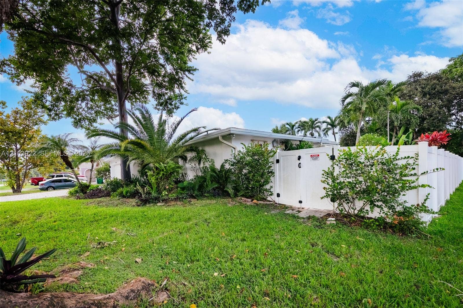 Manicured lawn with mature trees and tropical landscaping