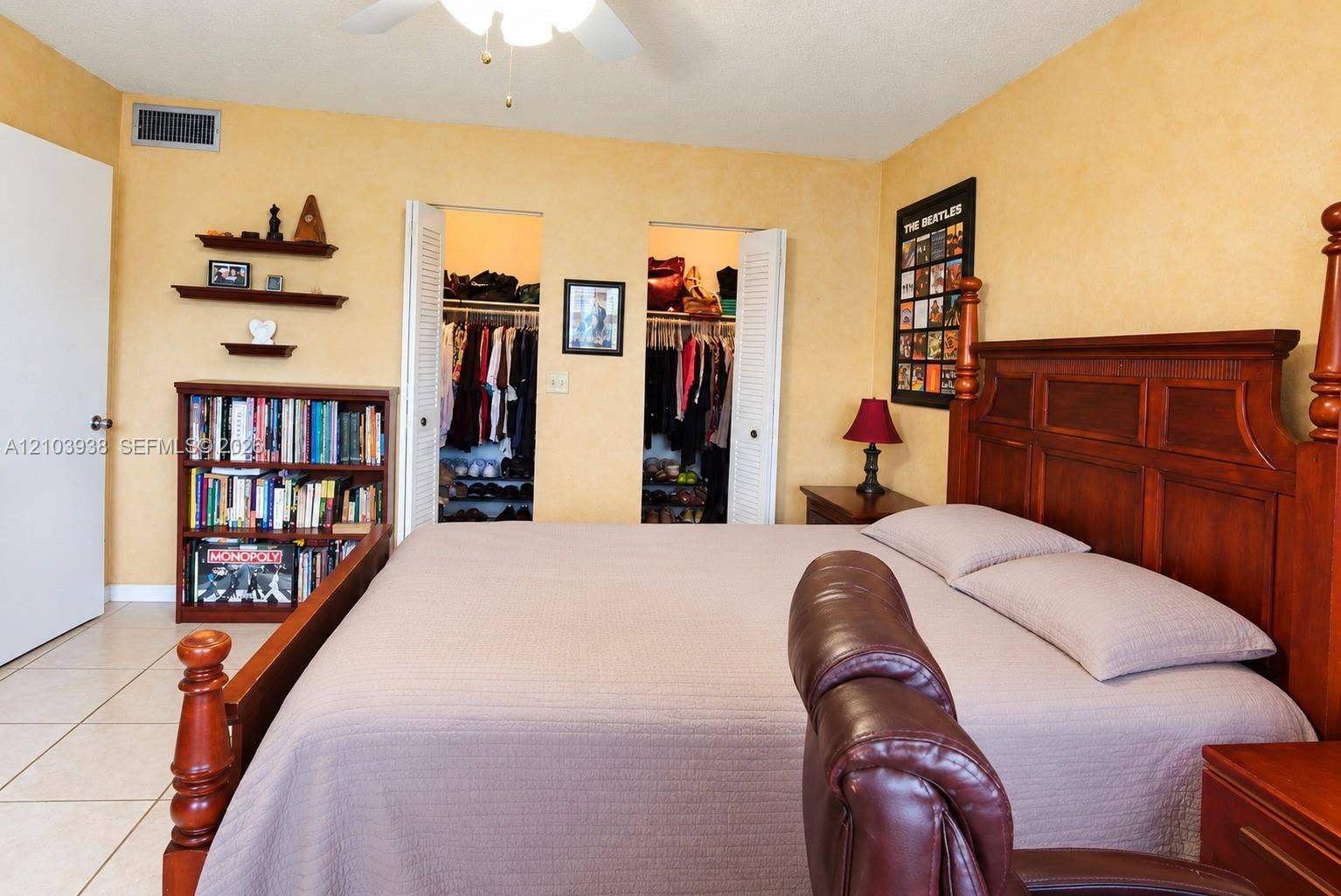 11335 SW 71st Lane, Miami, FL 33173 Room interior featuring neutral wall paint, tile flooring, dual closets with louvered doors, and a ceiling-mounted fan