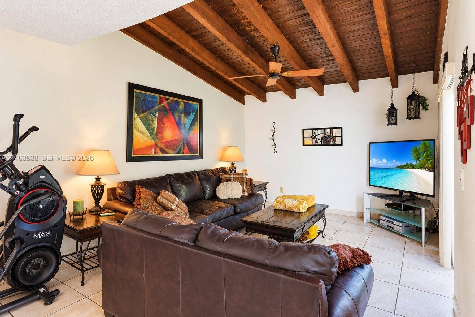 11335 SW 71st Lane, Miami, FL 33173 Vaulted ceiling featuring exposed wood beams, neutral floor tiling, and a ceiling fan with integrated lighting