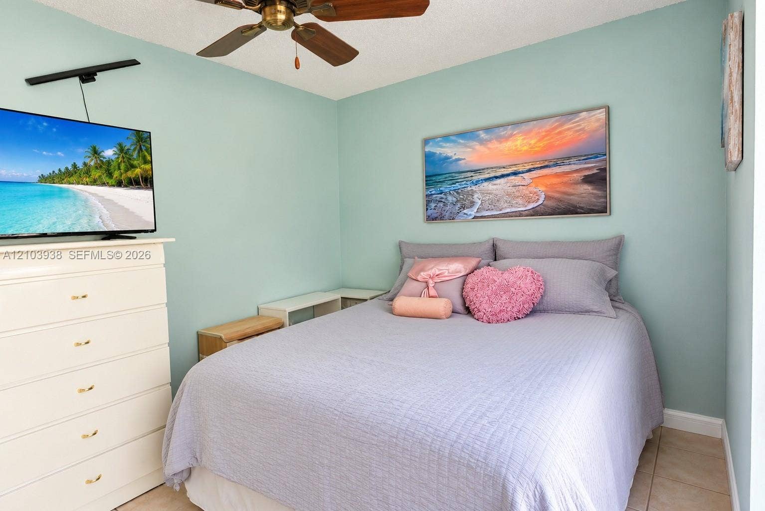 11335 SW 71st Lane, Miami, FL 33173 Bedroom featuring light blue wall paint, tile flooring, and a ceiling-mounted fan with dark wood-finish blades