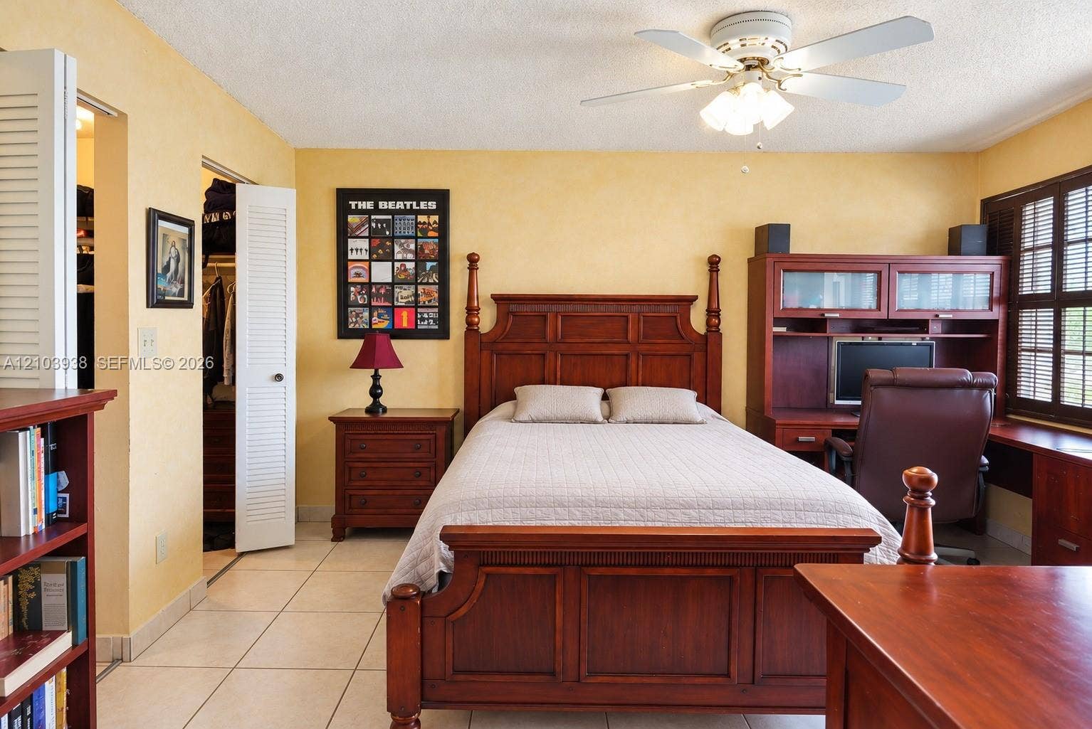 11335 SW 71st Lane, Miami, FL 33173 Room featuring tile flooring, ceiling fan with integrated lighting, louvered closet doors, and shutters