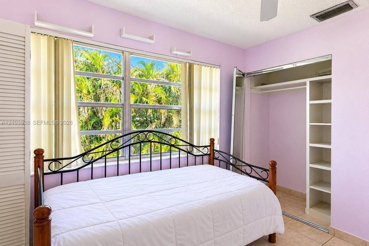 11335 SW 71st Lane, Miami, FL 33173 Large multi-pane window with natural exterior greenery, ceramic tile flooring, and built-in closet featuring shelving and hanging storage