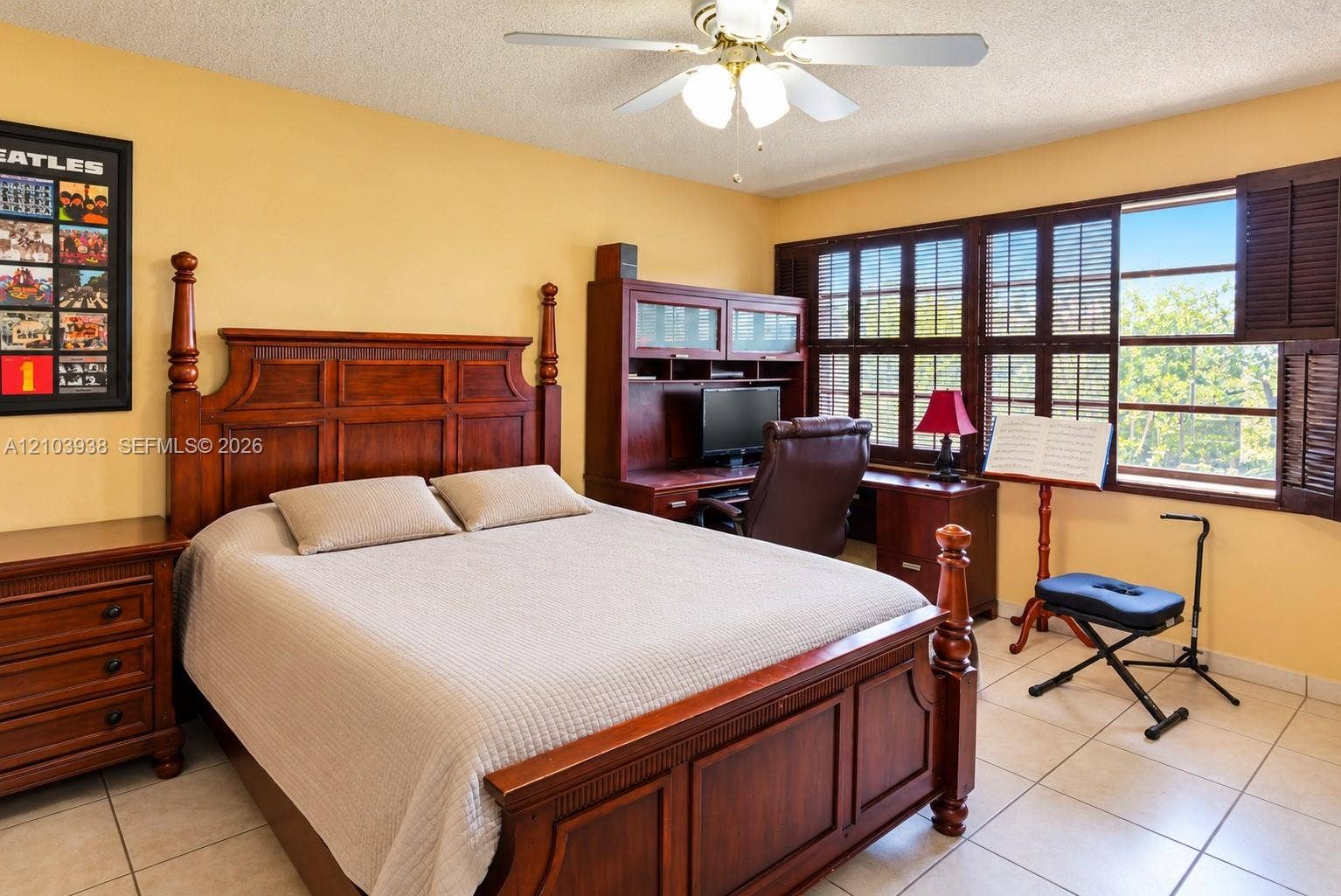 11335 SW 71st Lane, Miami, FL 33173 Tile flooring, wood-finish built-in desk unit, ceiling fan with light fixture, and windows featuring attached dark wood shutters