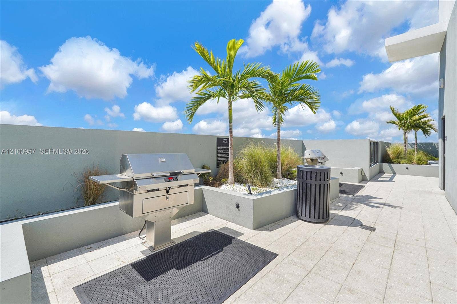 307 SW 5th Street, #0, Fort Lauderdale, Fort Lauderdale, FL 33315 Rooftop patio featuring a built-in stainless steel grill, planter beds with palm trees, and light-toned tile flooring