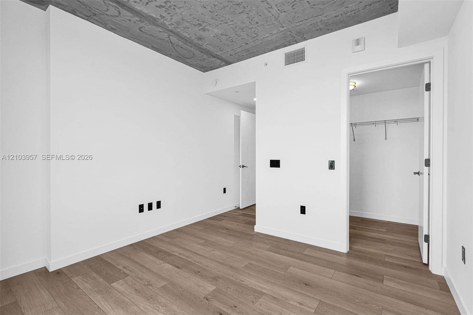 307 SW 5th Street, #0, Fort Lauderdale, Fort Lauderdale, FL 33315 Wood-finish flooring, white walls, exposed concrete ceiling, recessed lighting, and a closet with built-in shelving