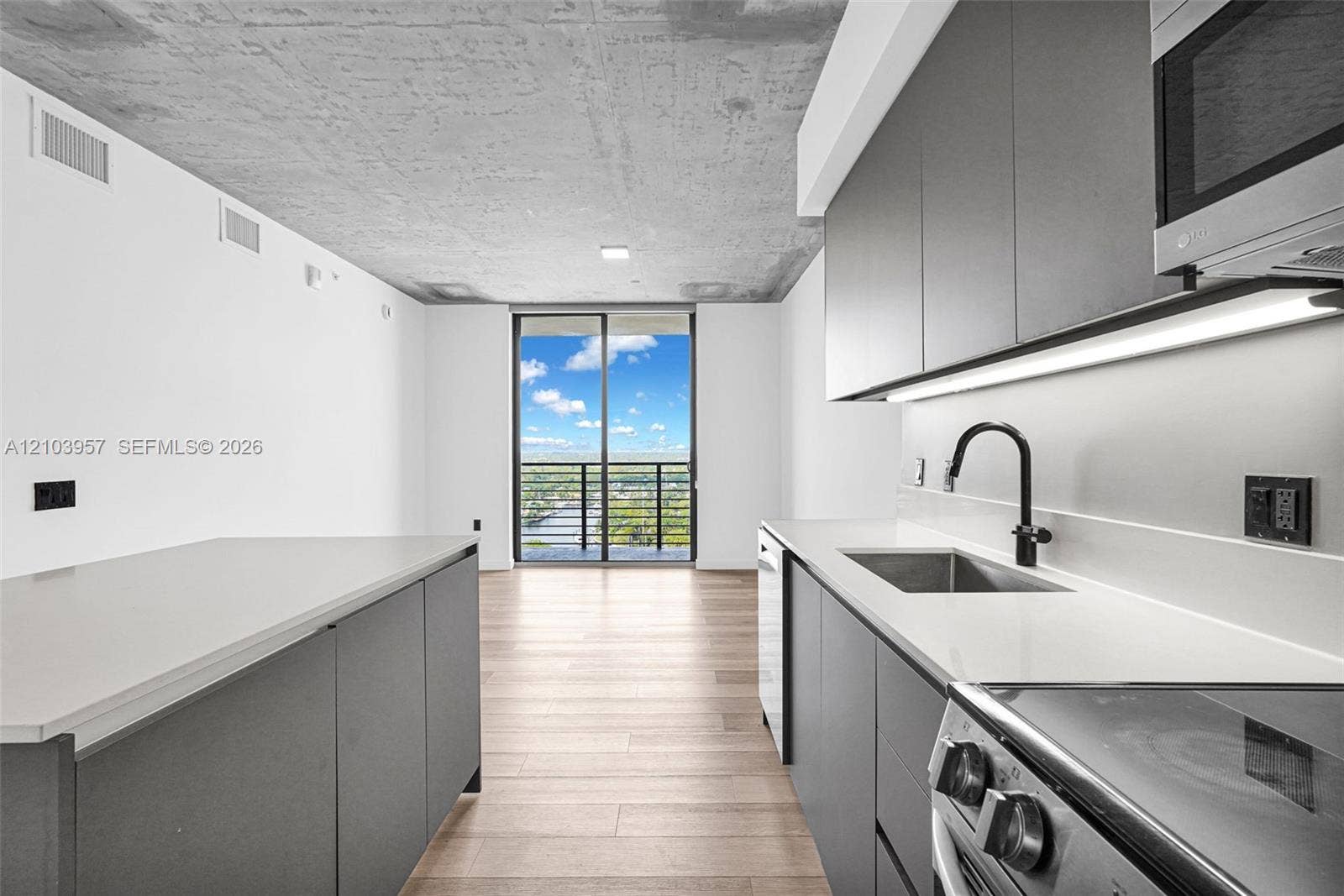 307 SW 5th Street, #0, Fort Lauderdale, Fort Lauderdale, FL 33315 Kitchen featuring dark gray cabinetry, light wood-finish flooring, white countertops, and a stainless steel sink with a matte black faucet