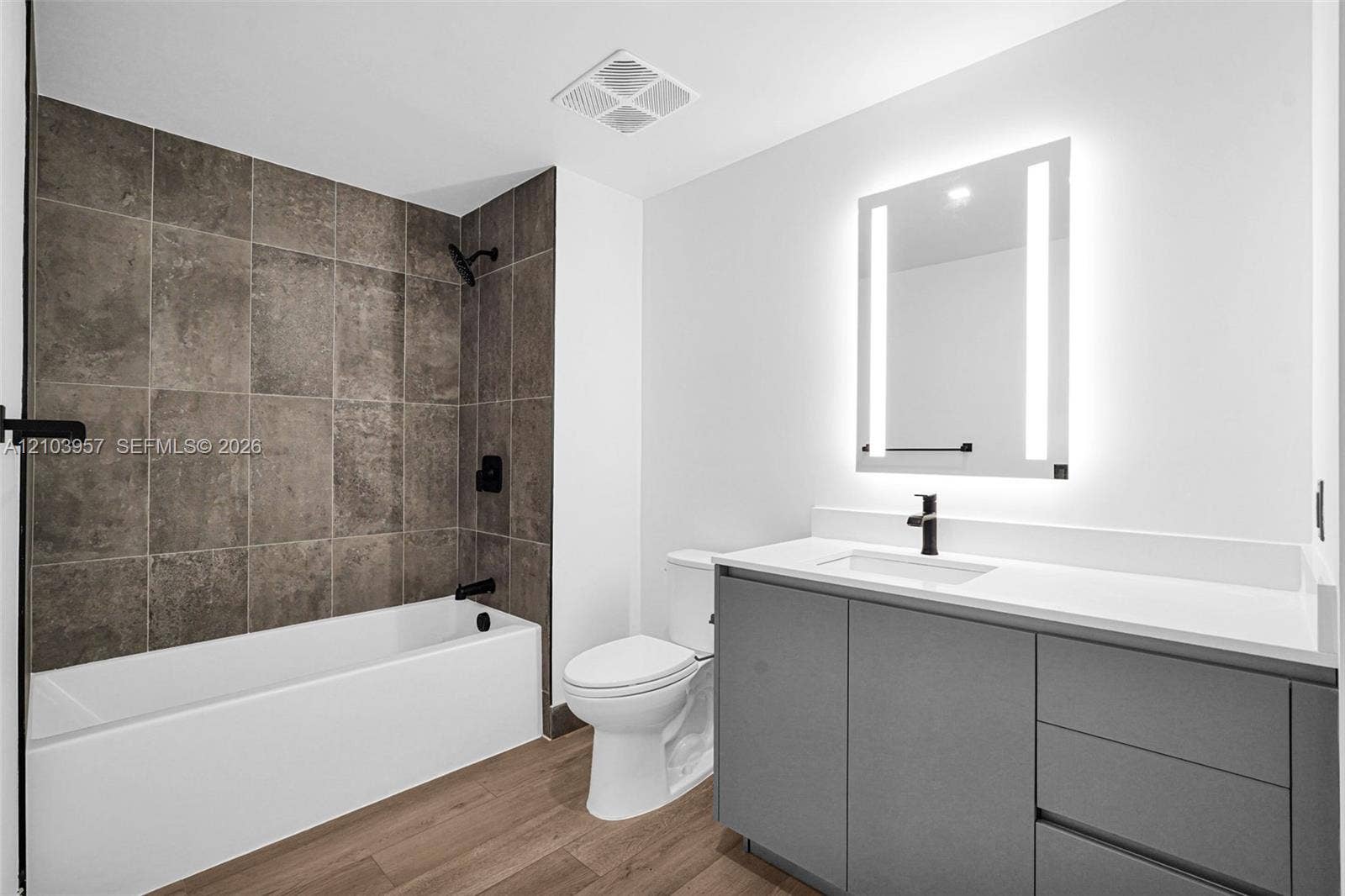 307 SW 5th Street, #0, Fort Lauderdale, Fort Lauderdale, FL 33315 White bathtub with dark-toned tile surround, matte black fixtures, and a wood-finish floor