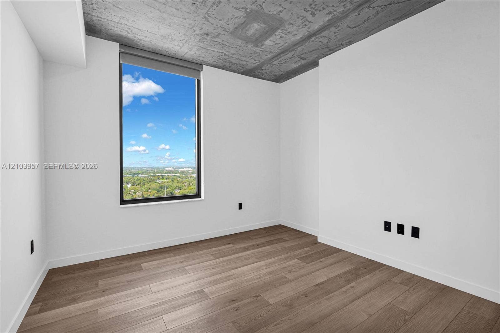 307 SW 5th Street, #0, Fort Lauderdale, Fort Lauderdale, FL 33315 Large window with a roller shade, wood-finish flooring, exposed concrete ceiling, and white walls