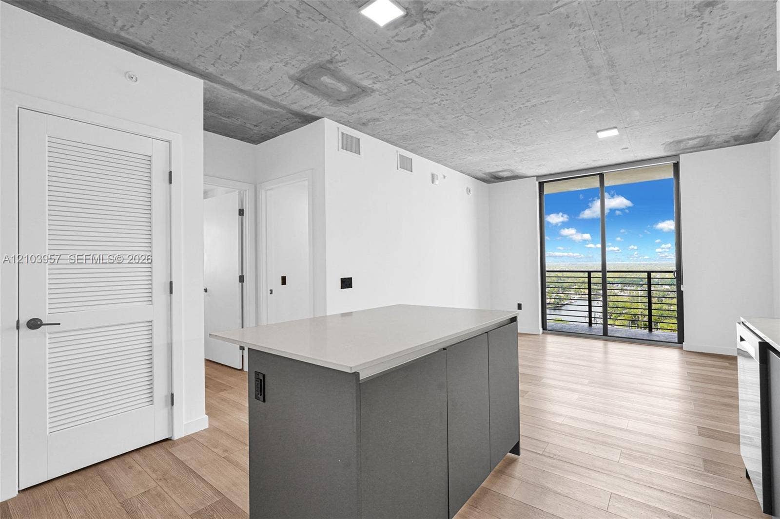 307 SW 5th Street, #0, Fort Lauderdale, Fort Lauderdale, FL 33315 Expansive sliding glass doors, concrete ceiling, wood-finish flooring, central island with light-toned countertop, and modern appliances