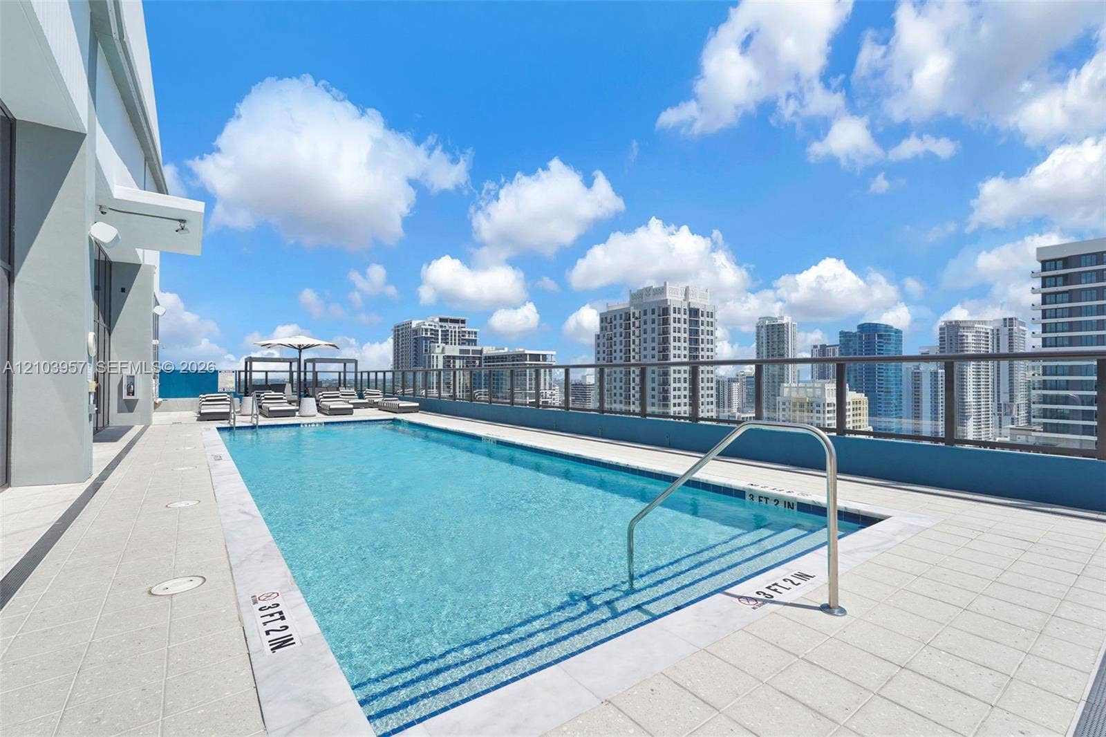 307 SW 5th Street, #0, Fort Lauderdale, Fort Lauderdale, FL 33315 Rooftop swimming pool featuring a city backdrop, clear blue water, and a glass-paneled railing