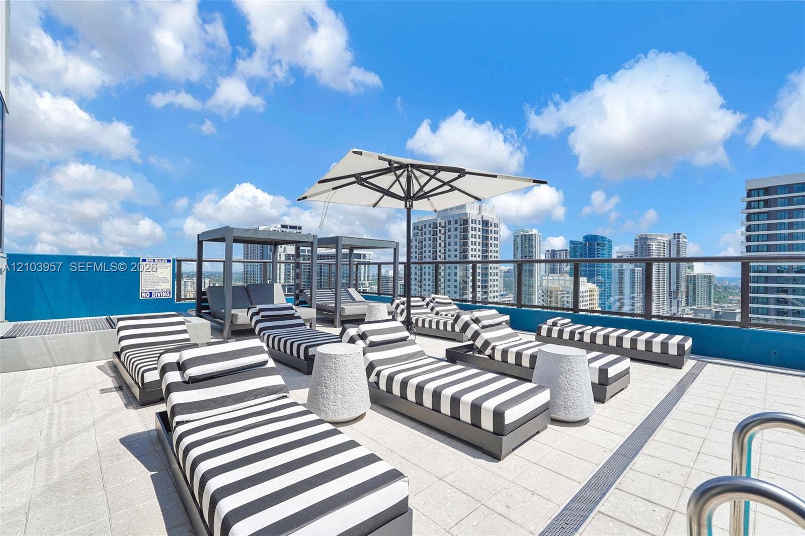 307 SW 5th Street, #0, Fort Lauderdale, Fort Lauderdale, FL 33315 Rooftop deck featuring a glass railing, tiled flooring, and a contemporary cityscape backdrop