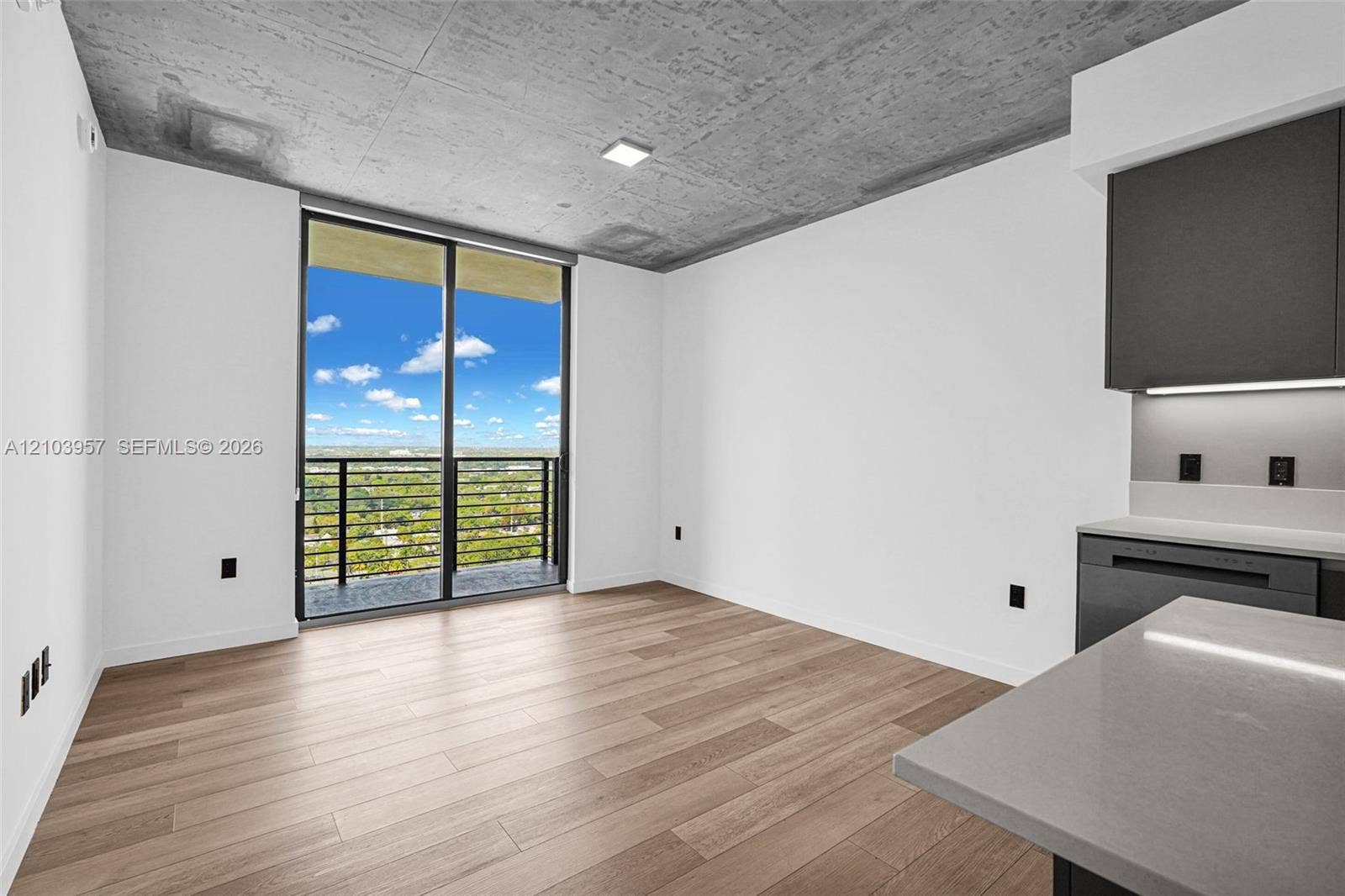 307 SW 5th Street, #0, Fort Lauderdale, Fort Lauderdale, FL 33315 Concrete ceiling, wood-finish flooring, sliding glass balcony doors, modern dark cabinetry, and light countertops