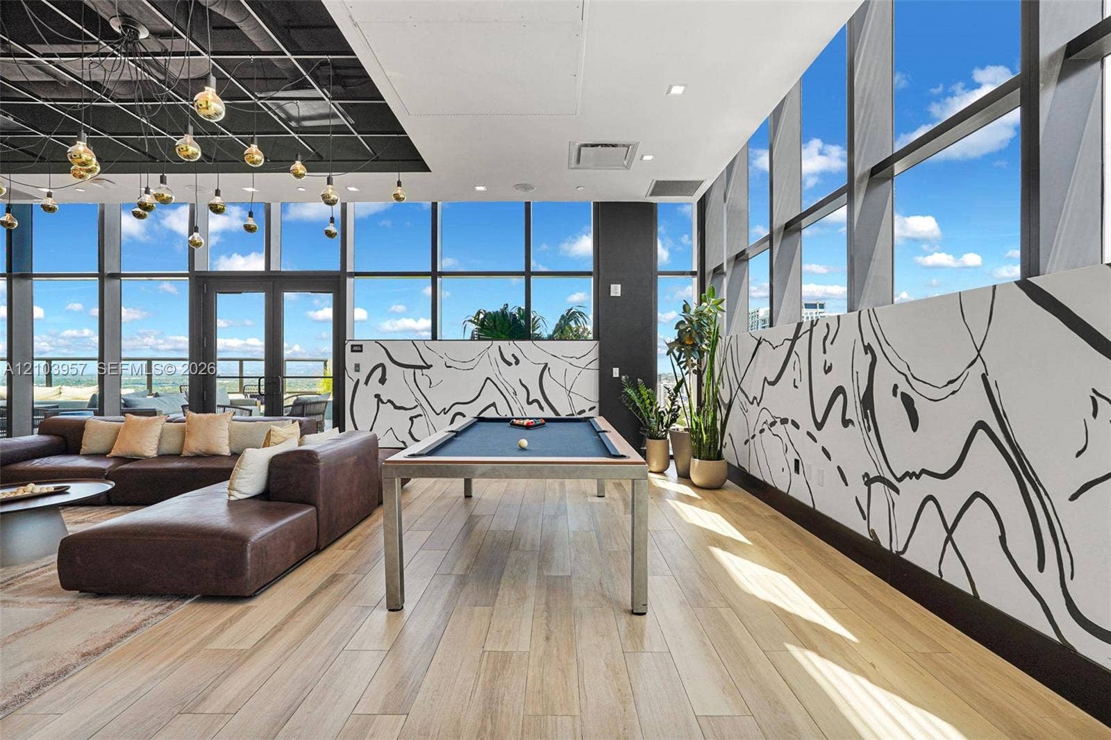 307 SW 5th Street, #0, Fort Lauderdale, Fort Lauderdale, FL 33315 Floor-to-ceiling windows, wood-finish flooring, exposed ceiling, double-door outdoor access, and contemporary wall art