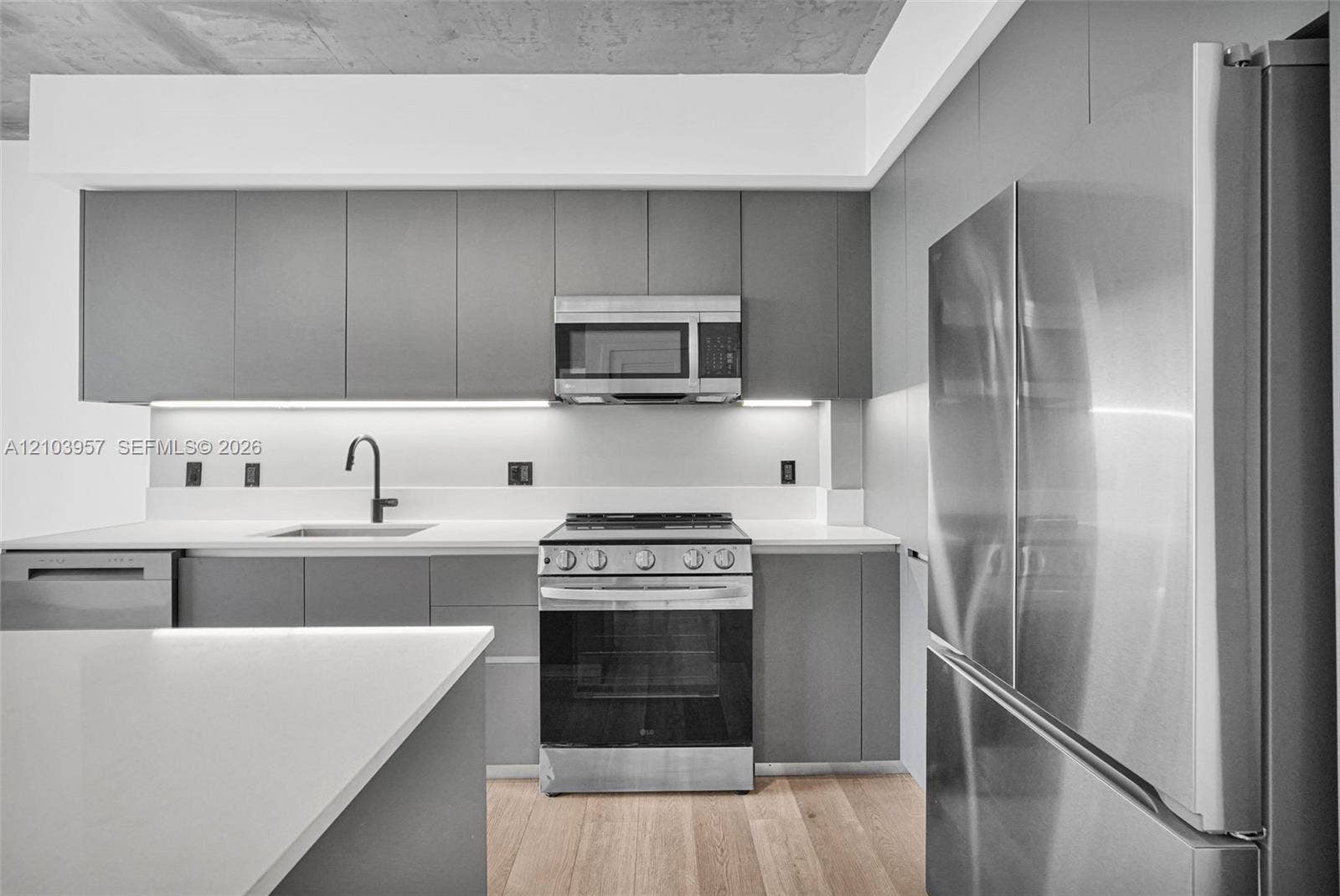 307 SW 5th Street, #0, Fort Lauderdale, Fort Lauderdale, FL 33315 Kitchen featuring stainless steel appliances, light wood-finish flooring, white countertops, gray cabinetry, and under-cabinet lighting