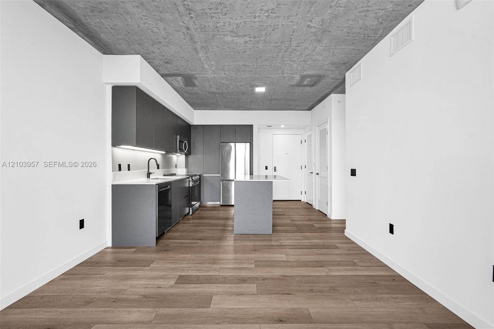307 SW 5th Street, #0, Fort Lauderdale, Fort Lauderdale, FL 33315 Modern kitchen featuring dark cabinetry, stainless steel appliances, light-toned countertops, a kitchen island, and wood-finish flooring