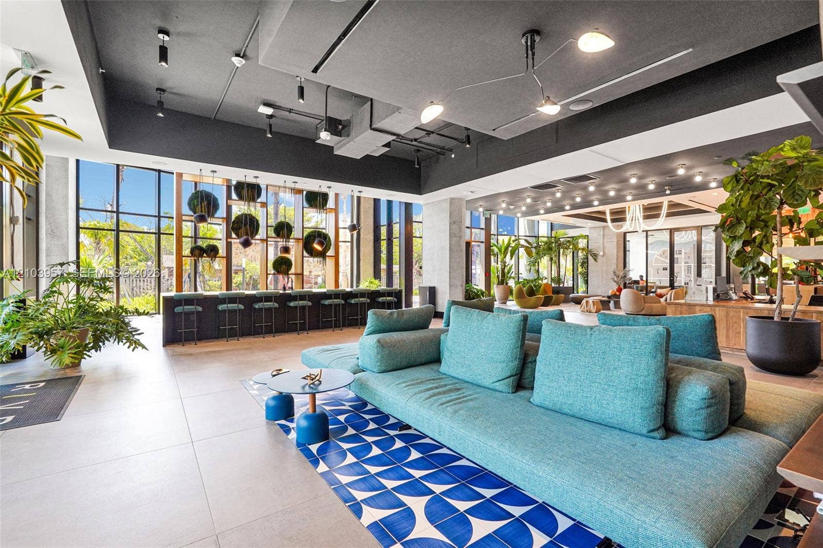 307 SW 5th Street, #0, Fort Lauderdale, Fort Lauderdale, FL 33315 Expansive lounge area featuring floor-to-ceiling windows, a long bar area with seating, recessed lighting, and a patterned tile accent rug