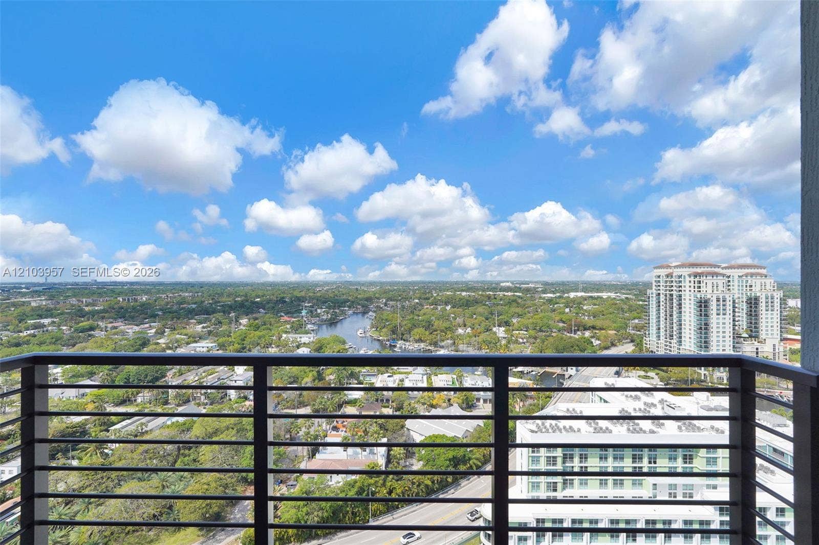 307 SW 5th Street, #0, Fort Lauderdale, Fort Lauderdale, FL 33315 High-rise balcony with horizontal metal railings, overlooking a waterway, urban landscape, and distant buildings