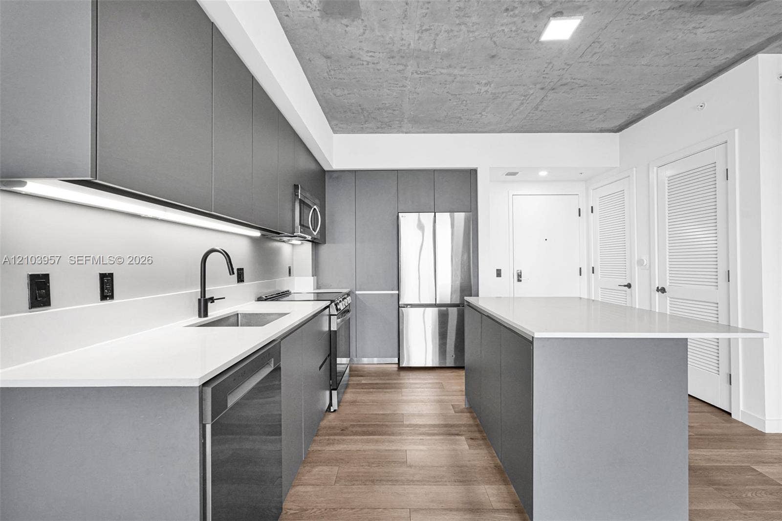 307 SW 5th Street, #0, Fort Lauderdale, Fort Lauderdale, FL 33315 Modern kitchen featuring light wood-finish flooring, white countertops, gray flat-panel cabinetry, stainless steel appliances, and a central island