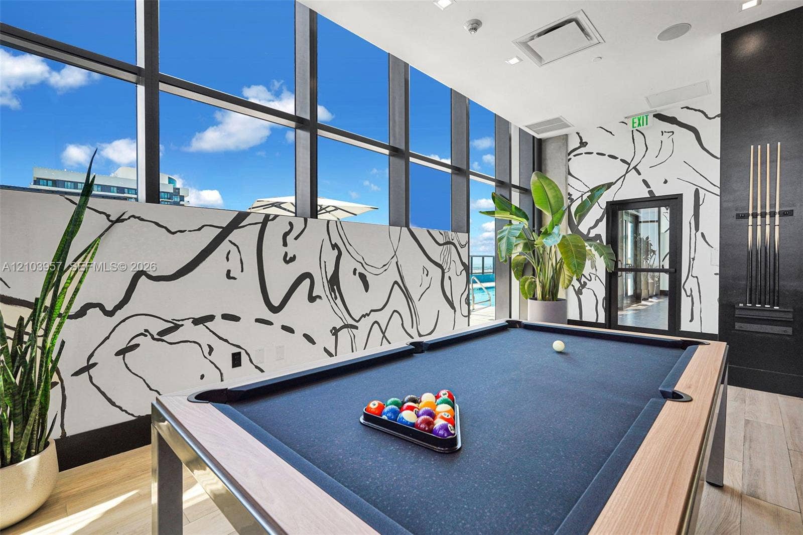 307 SW 5th Street, #0, Fort Lauderdale, Fort Lauderdale, FL 33315 Expansive window wall, contemporary wall mural, wood-finish flooring, and a built-in cue rack