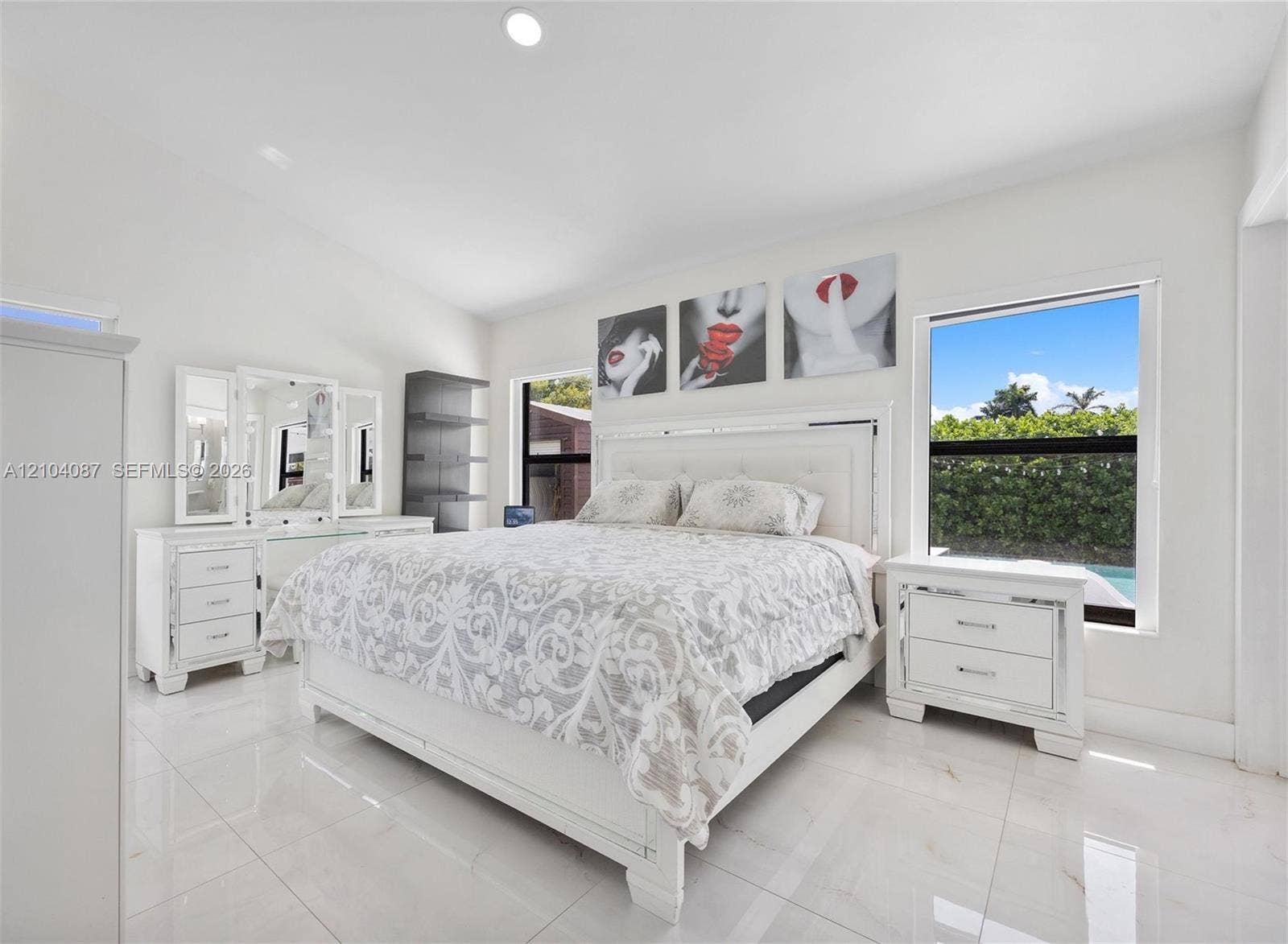 Vaulted ceilings, white tile flooring, and a large window