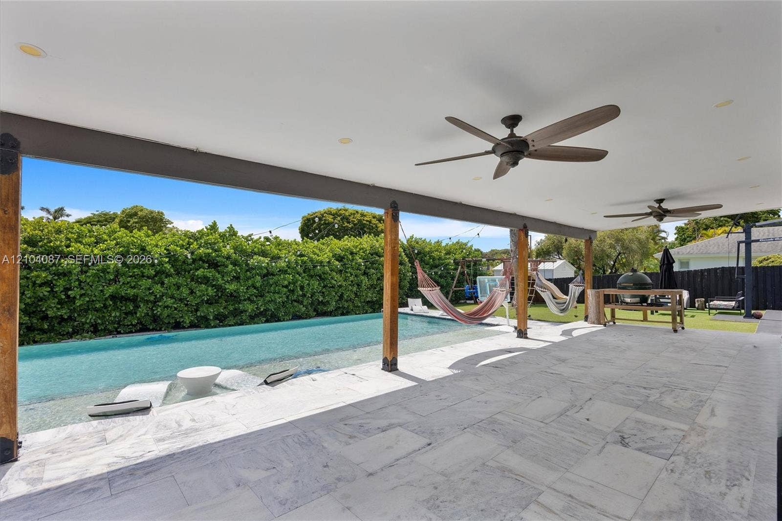 8840 SW 181st Terrace, Palmetto Bay, FL 33157 Covered patio featuring a swimming pool, multiple ceiling fans, and a tiled surface