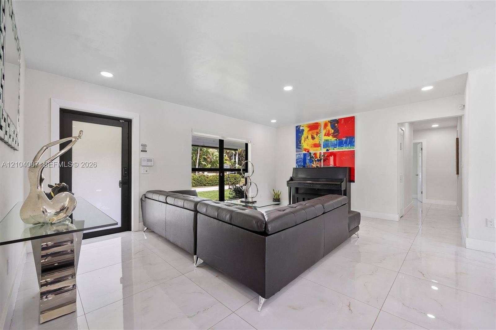 White tile flooring, recessed lighting, white walls, and a black framed glass door