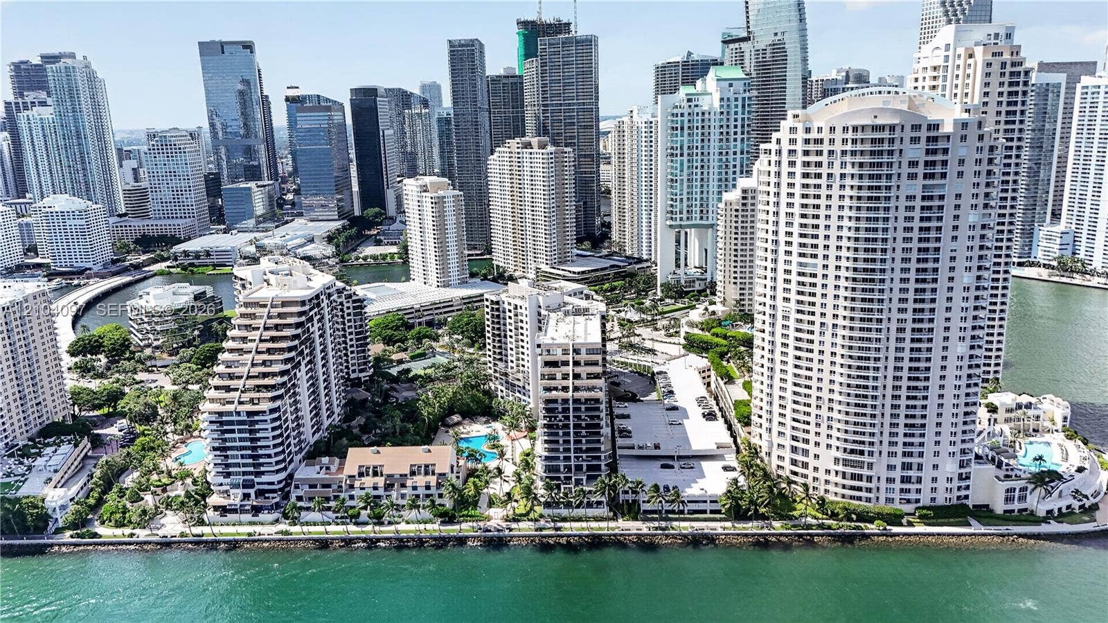 540 Brickell Key Drive, #916, Miami, Miami, FL 33131 Aerial perspective of a waterfront high-rise urban district featuring multi-story residential structures, coastal seawalls, swimming pools, and extensive palm-lined landscaping