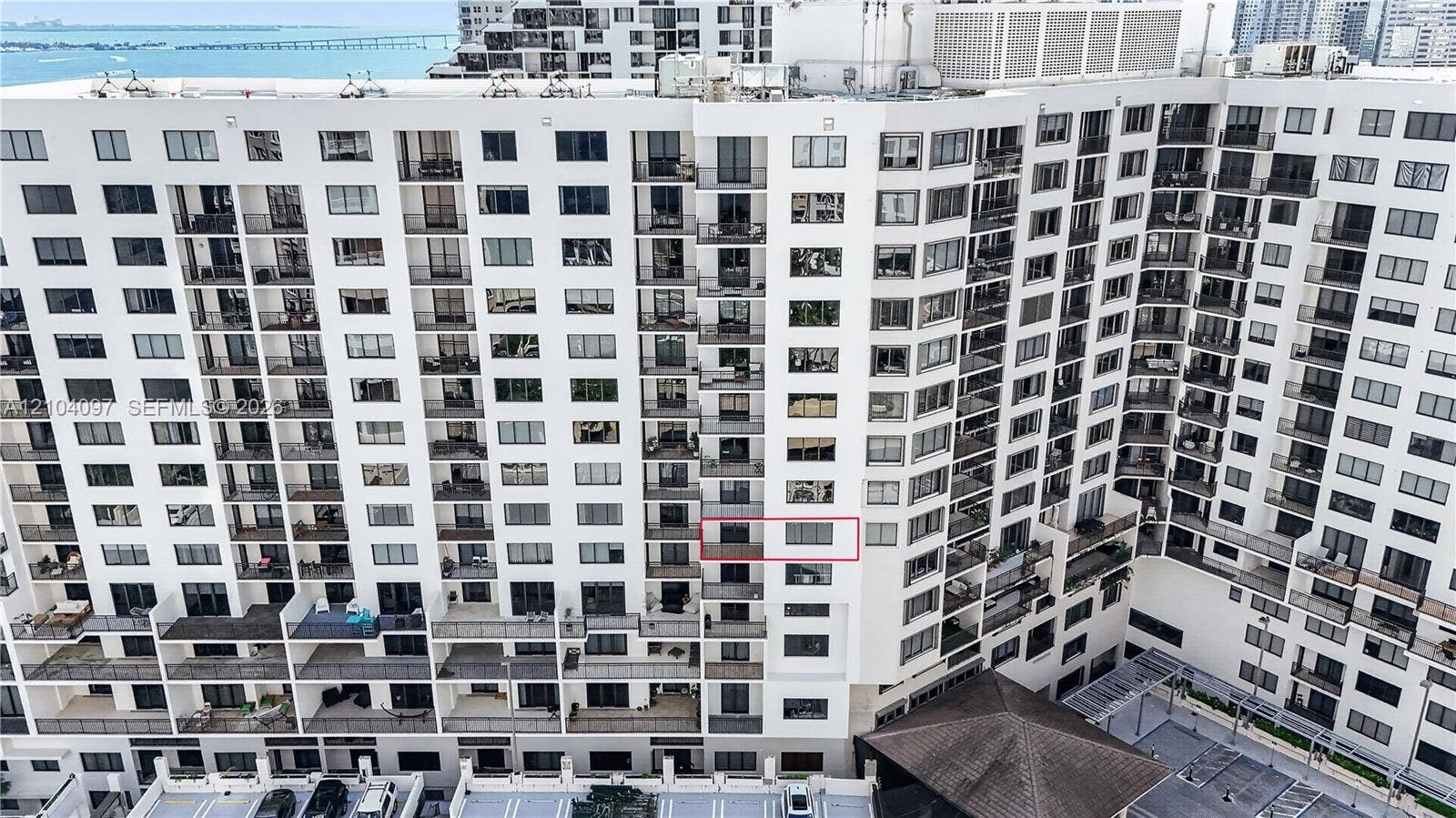 540 Brickell Key Drive, #916, Miami, Miami, FL 33131 High-rise condominium exterior featuring tiered balconies, white stucco facade, floor-to-ceiling glass doors, and water proximity