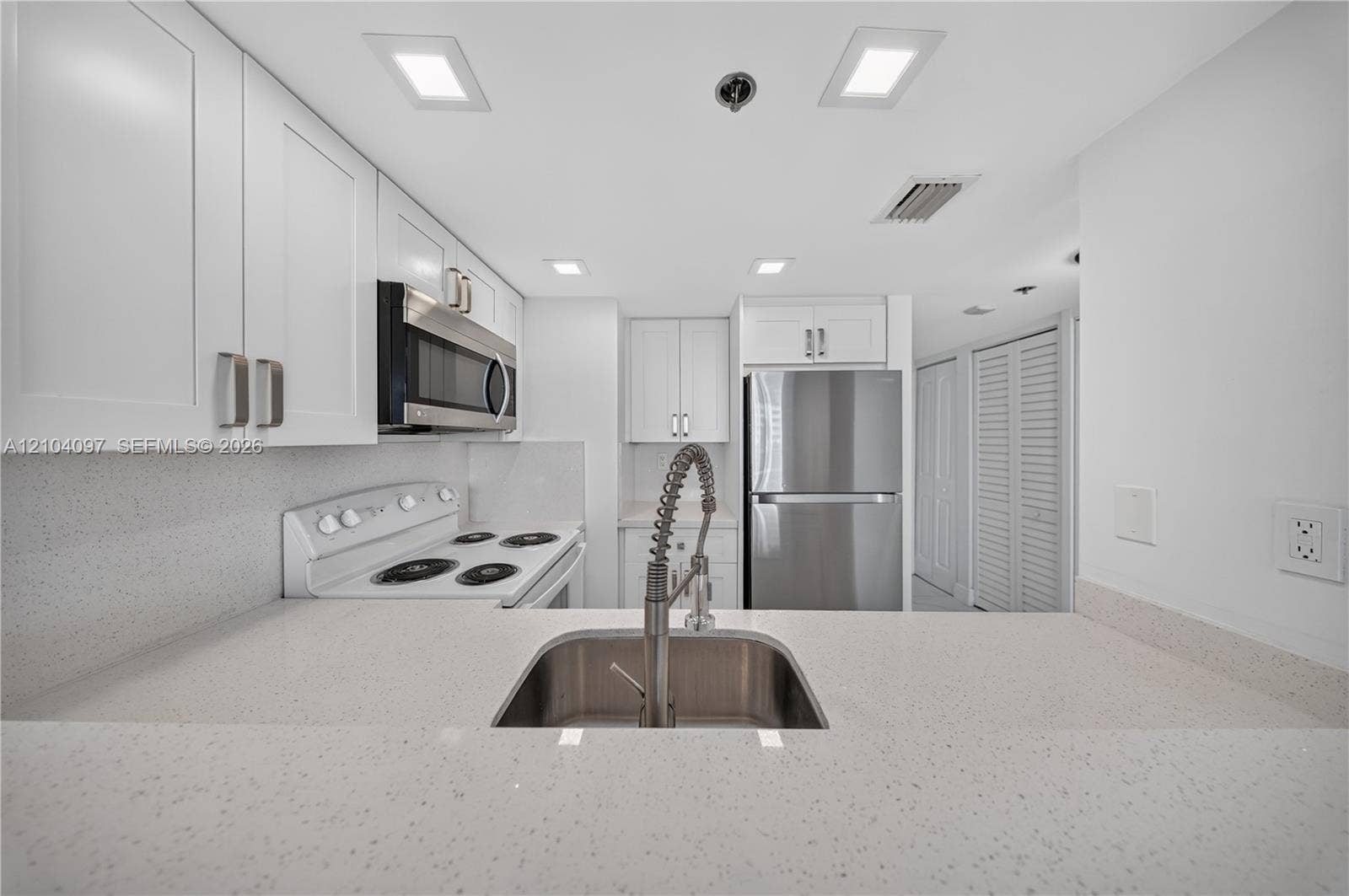 540 Brickell Key Drive, #916, Miami, Miami, FL 33131 Kitchen featuring white shaker cabinetry, speckled quartz countertops, stainless steel appliances, and a gooseneck faucet