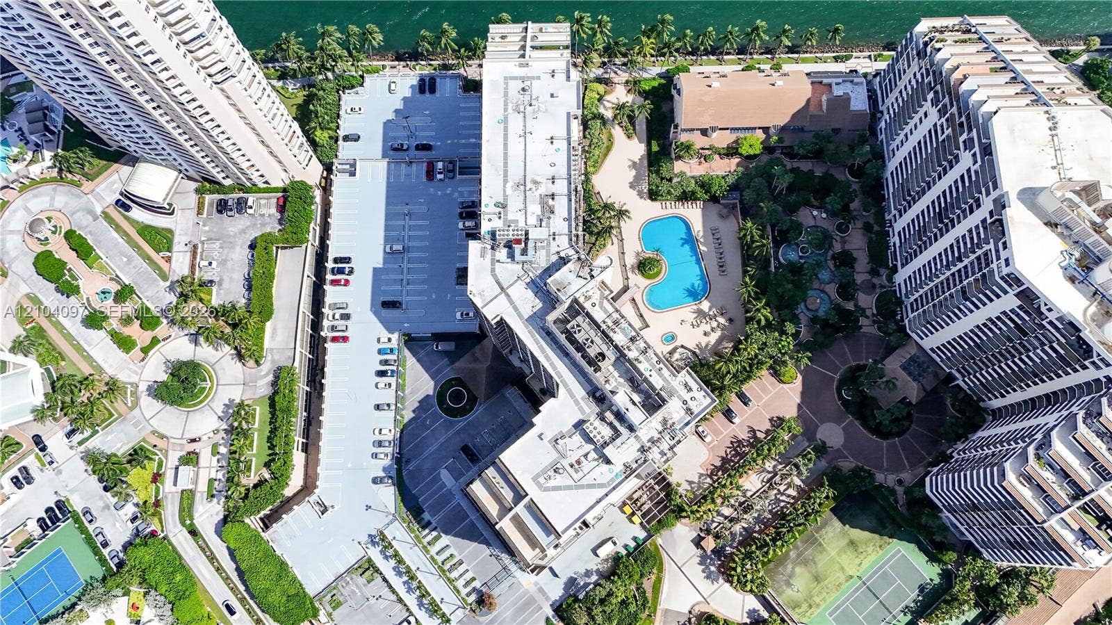 540 Brickell Key Drive, #916, Miami, Miami, FL 33131 Aerial view featuring a multi-building residential complex, an outdoor swimming pool, paved surface parking, and tennis courts