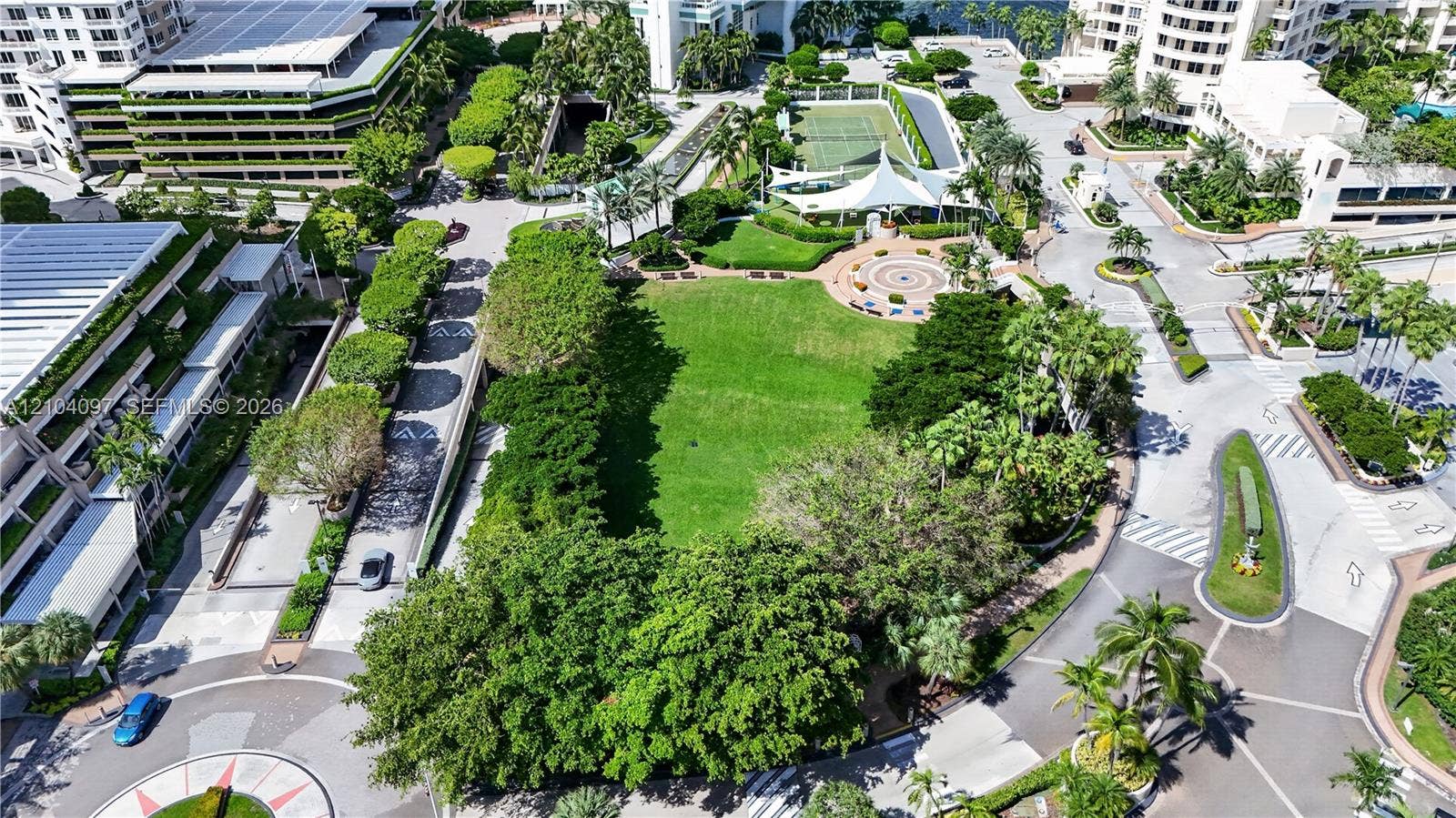 540 Brickell Key Drive, #916, Miami, Miami, FL 33131 Aerial perspective of the community grounds featuring a central expansive lawn, mature landscaping, paved pathways, and a tennis court