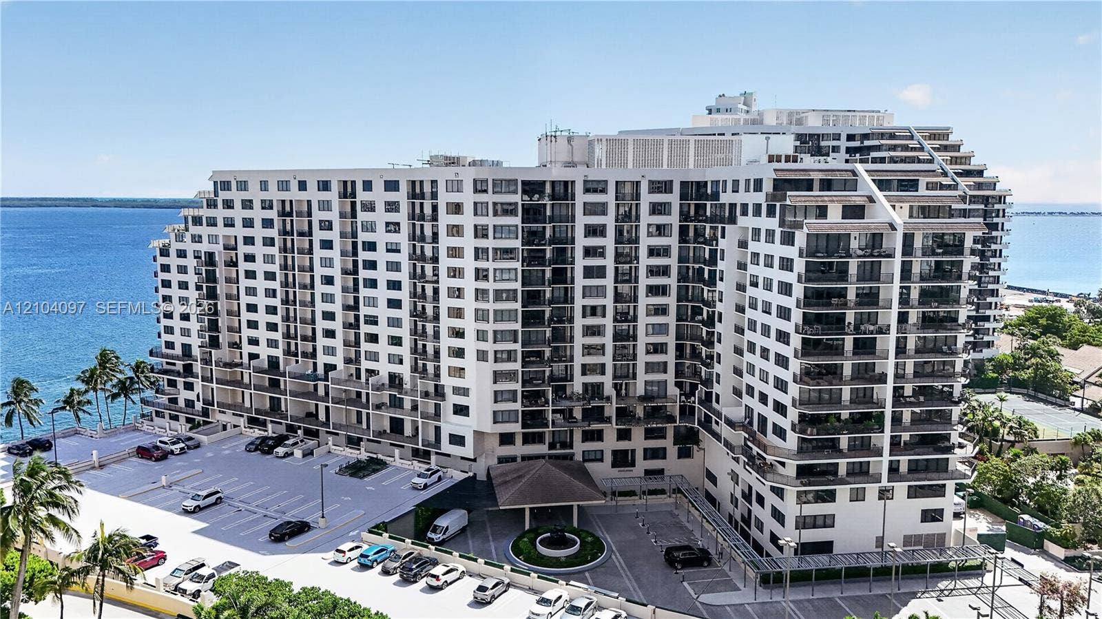 540 Brickell Key Drive, #916, Miami, Miami, FL 33131 Multi-story high-rise building featuring private balconies, surface parking, paved drive entry, and waterfront positioning