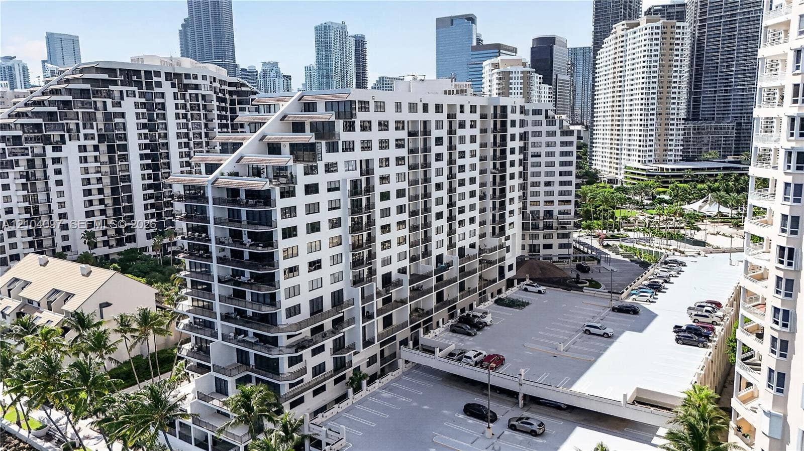 540 Brickell Key Drive, #916, Miami, Miami, FL 33131 Multi-story residential building featuring private recessed balconies, a structured parking area, and manicured palm landscaping
