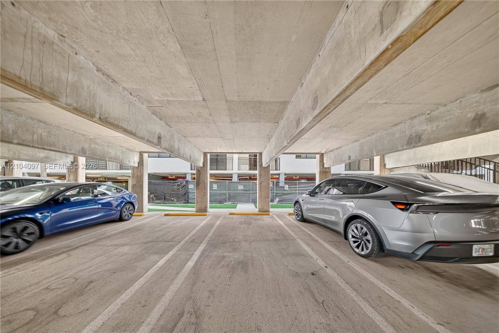 540 Brickell Key Drive, #916, Miami, Miami, FL 33131 Covered parking garage featuring structural concrete beams, concrete flooring, and designated stalls