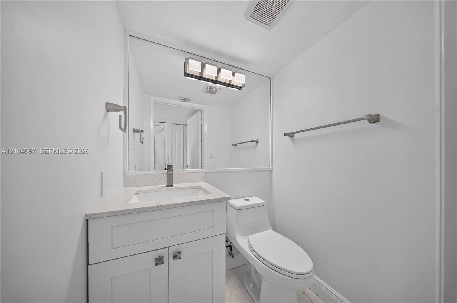 540 Brickell Key Drive, #916, Miami, Miami, FL 33131 Bathroom featuring white cabinetry, stone-finish countertop, single-basin integrated sink, chrome-finish faucet, and a wall-mounted four-light fixture