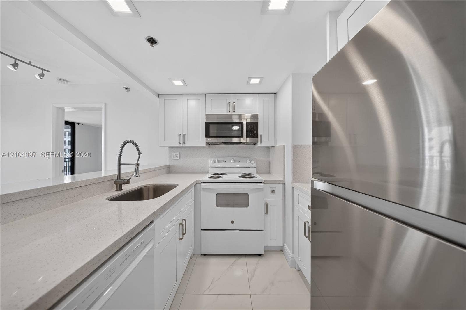 540 Brickell Key Drive, #916, Miami, Miami, FL 33131 Kitchen featuring white cabinetry, solid surface countertops, stainless steel appliances, a pull-down kitchen faucet, and tile flooring