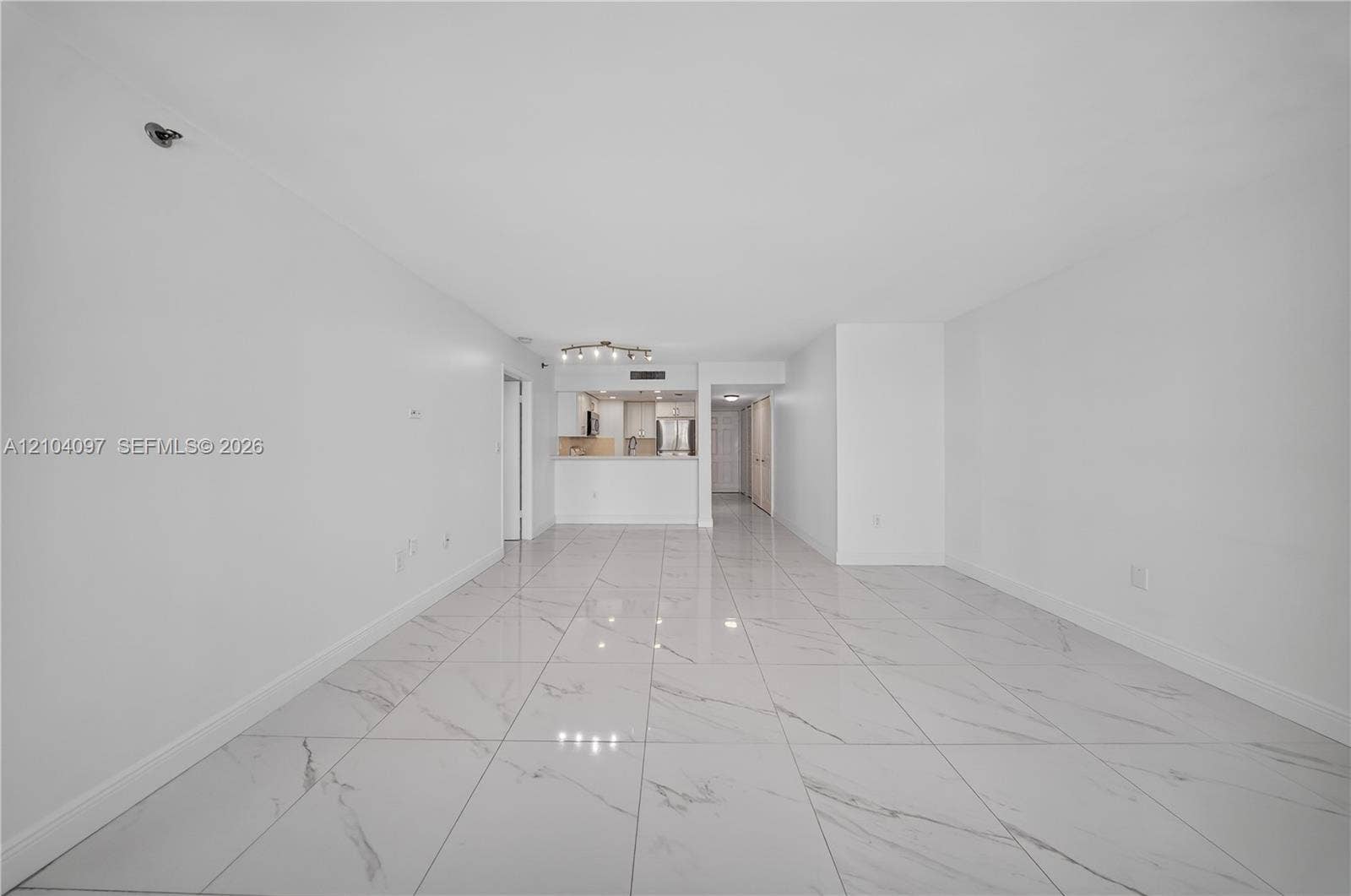 540 Brickell Key Drive, #916, Miami, Miami, FL 33131 Large-format tile flooring, neutral walls, and a recessed kitchen featuring cabinetry with stainless steel appliances