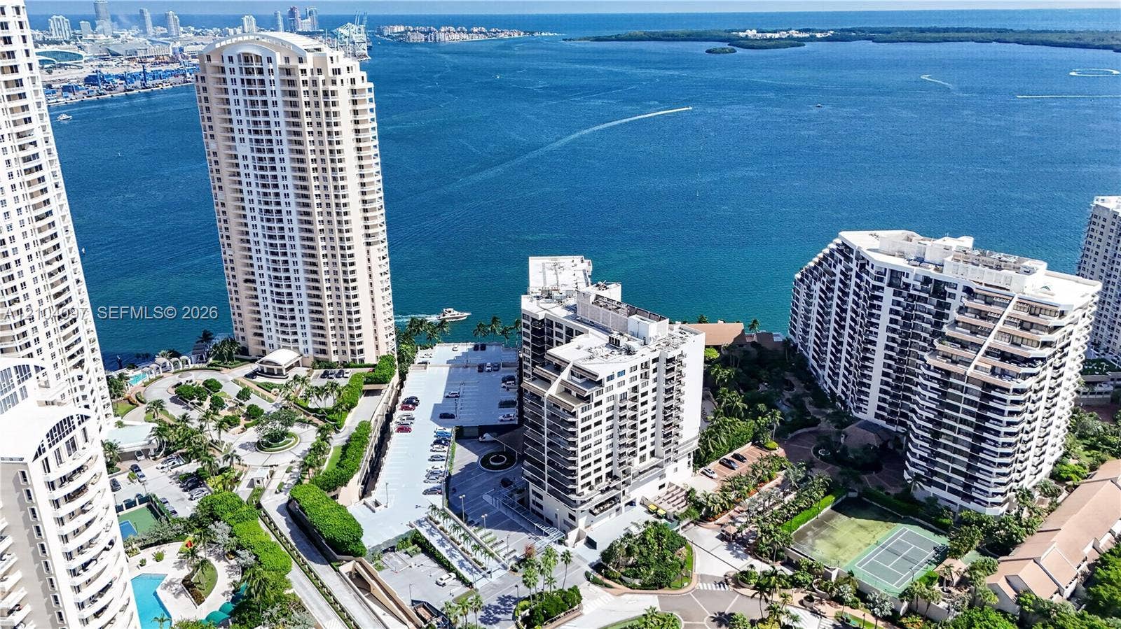 540 Brickell Key Drive, #916, Miami, Miami, FL 33131 Aerial perspective featuring multiple high-rise residential buildings, waterfront access, hardscaped parking areas, and on-site tennis courts