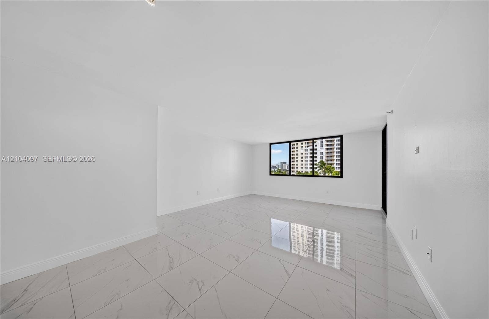 540 Brickell Key Drive, #916, Miami, Miami, FL 33131 Open-concept interior featuring large-format tile flooring with marble-finish detailing and a black-framed window