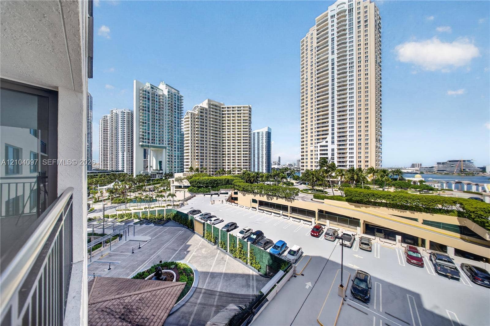 540 Brickell Key Drive, #916, Miami, Miami, FL 33131 Balcony featuring a metal railing with outdoor scenery including a multi-level parking structure, landscaped grounds, and metropolitan high-rise buildings